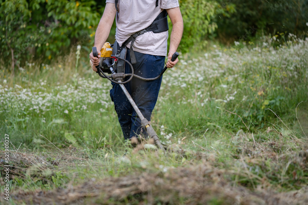 caucasian man farmer using string trimmer to cut grass brush cutter caucasian man farmer using string trimmer to cut grass brush cutter