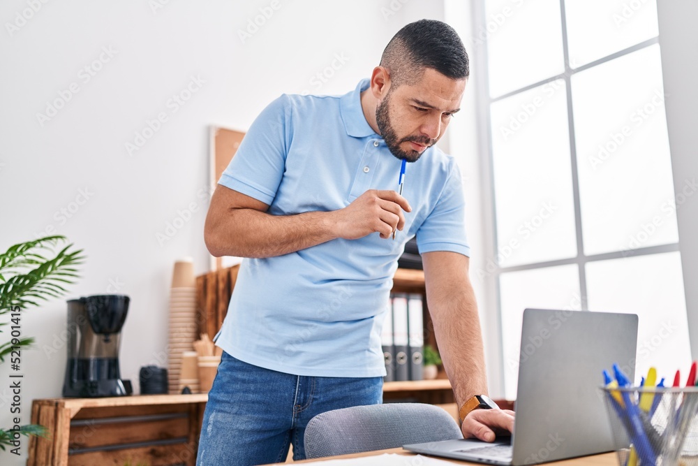 Young latin man business worker using laptop working at office