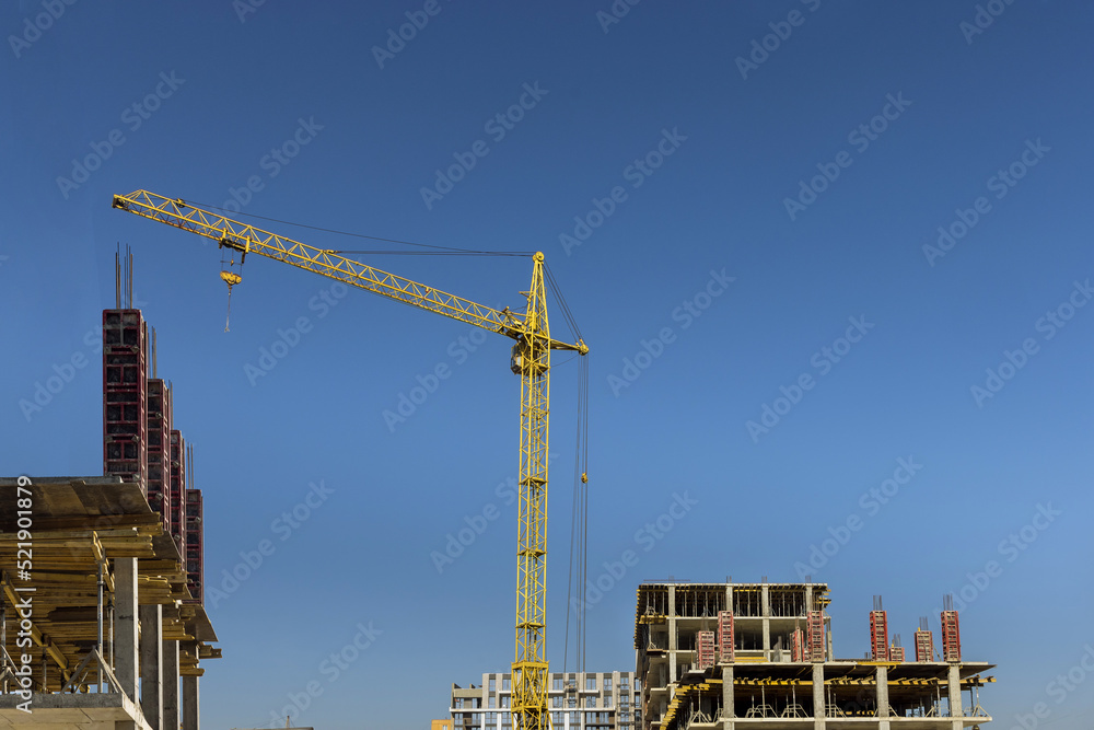 Multi-storey apartment building is being constructed using tower cranes that can reach heights as the work progresses along the building
