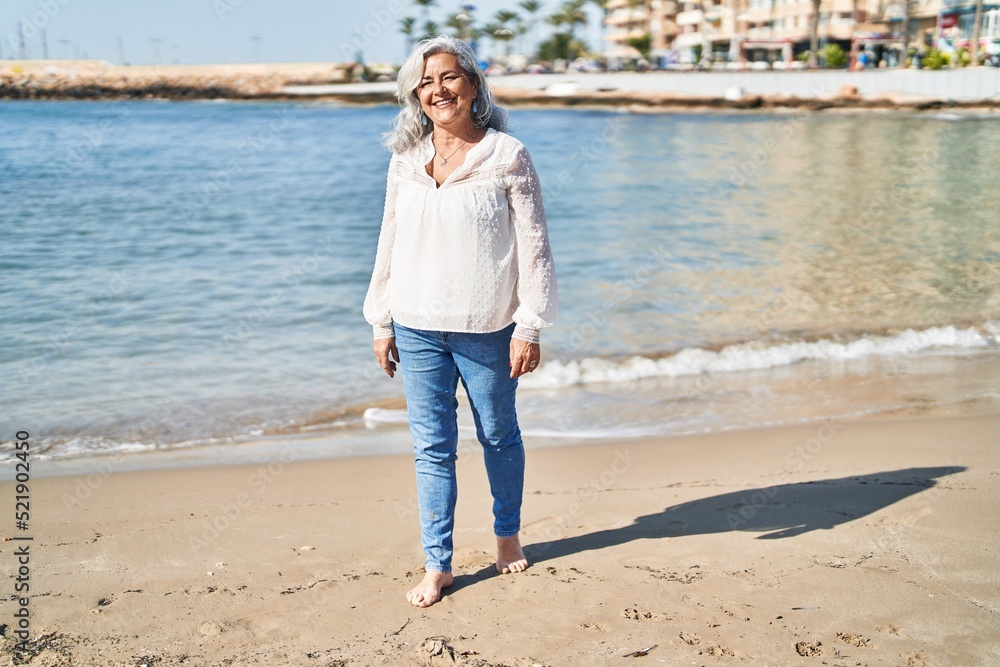 Middle age woman smiling confident standing at seaside Middle age woman smiling confident standing at seaside