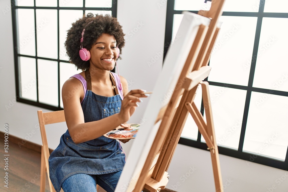 Young african american woman listening to music drawing at art studio