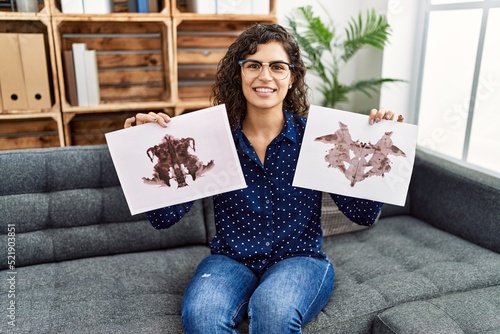 Young latin woman having psychology session doing rorscharch test at psychology center photo