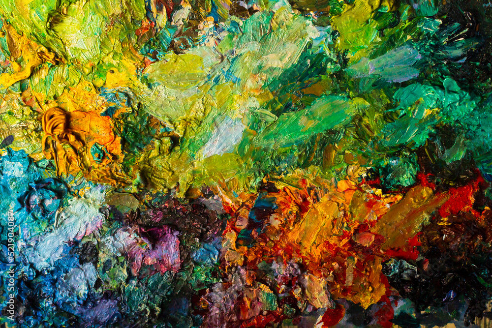 Fototapeta premium Background for artistic themes. The texture of the artist's palette close-up with yellow, green, blue and red colors