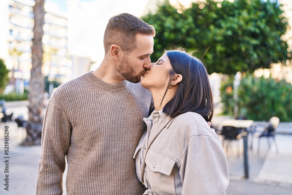 Obraz premium Man and woman couple hugging each other kissing at street