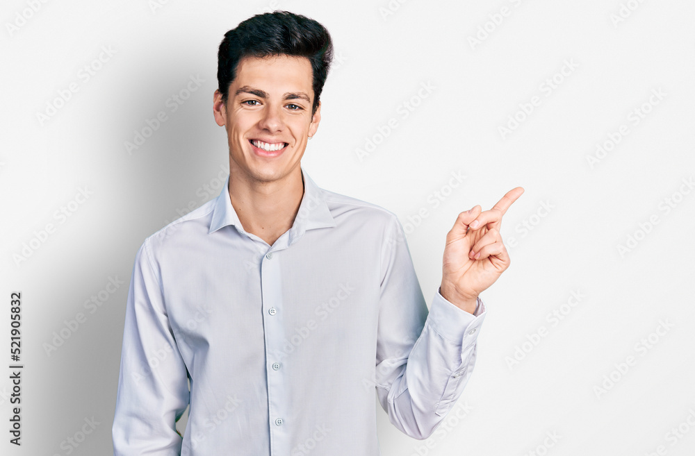 Young hispanic business man wearing business clothes with a big smile on face, pointing with hand and finger to the side looking at the camera. Young hispanic business man wearing business clothes with a big smile on face, pointing with hand and finger to the side looking at the camera.