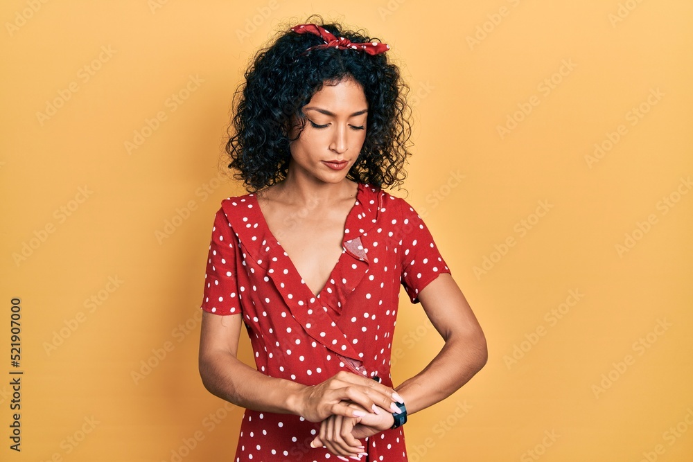 Young latin girl wearing summer dress checking the time on wrist watch, relaxed and confident Young latin girl wearing summer dress checking the time on wrist watch, relaxed and confident