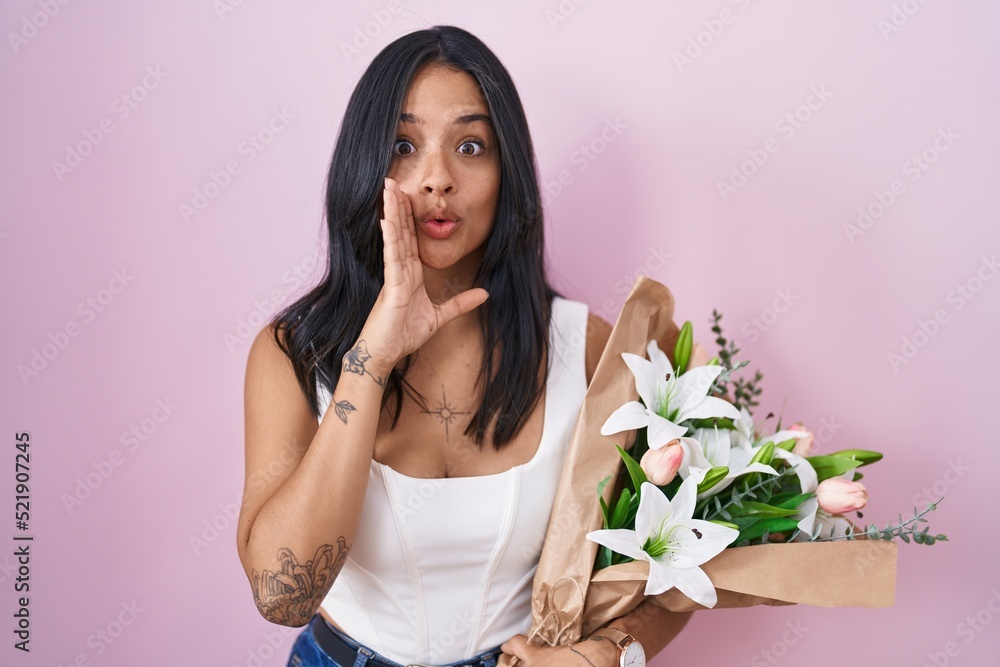 Brunette woman holding bouquet of white flowers hand on mouth telling secret rumor, whispering malicious talk conversation Brunette woman holding bouquet of white flowers hand on mouth telling secret rumor, whispering malicious talk conversation