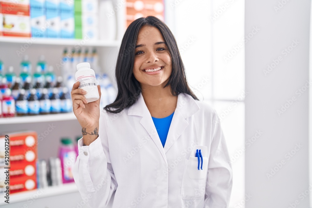 Young hispanic woman pharmacist smiling confident holding pills bottle at pharmacy Young hispanic woman pharmacist smiling confident holding pills bottle at pharmacy