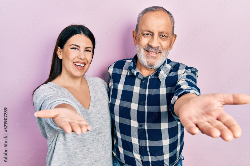 Hispanic father and daughter wearing casual clothes smiling friendly offering handshake as greeting and welcoming. successful business. Hispanic father and daughter wearing casual clothes smiling friendly offering handshake as greeting and welcoming. successful business.