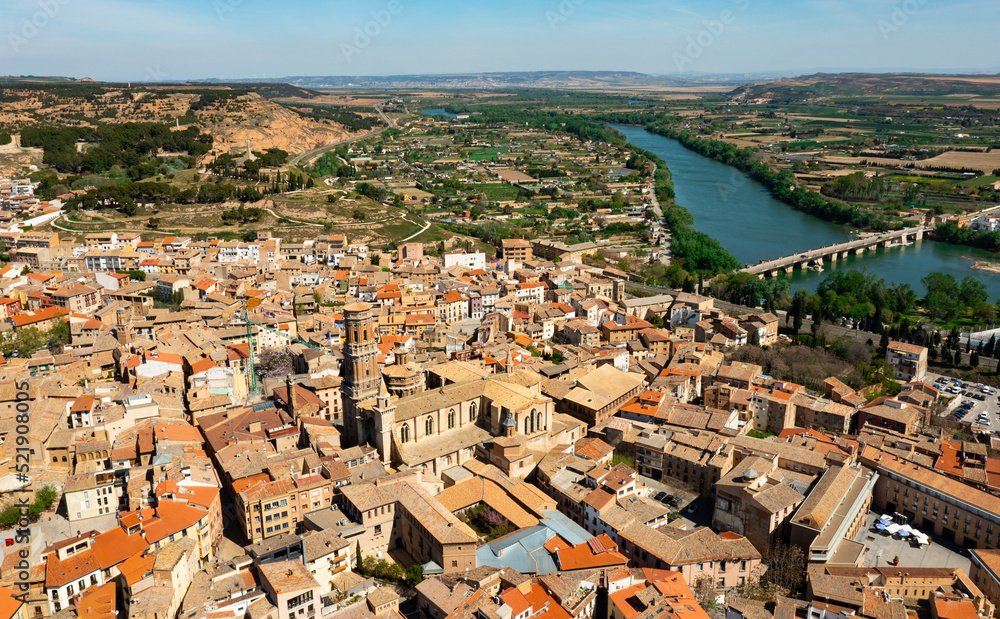 Scenic drone view of Spanish city of Tudela located in Ebro river valley overlooking ancient arched stone bridge and Roman Catholic cathedral in historic center on sunny spring day, Navarre
