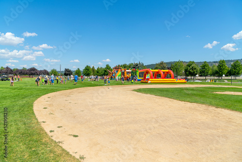 Families play at Pavilion Park during a summer festival and fair in the Spokane Washington suburb of Liberty Lake, Washington.