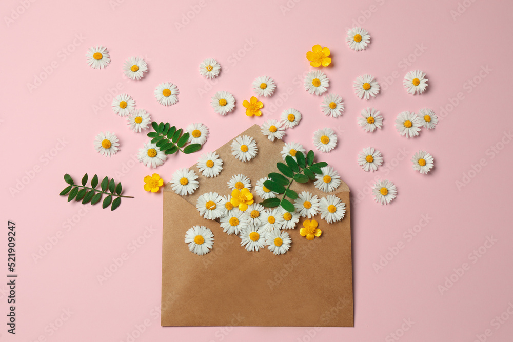 Fototapeta premium Flat lay composition with beautiful flowers, leaves and envelope on pink background