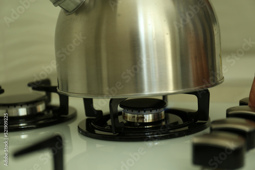 Kettle on gas burner of stove in kitchen, closeup