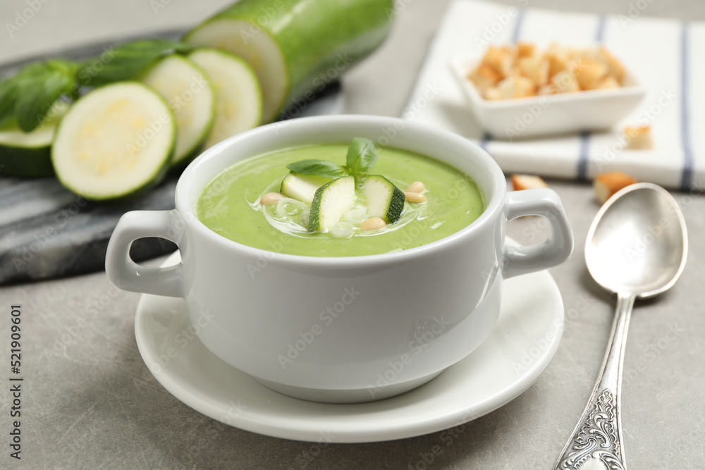 Tasty homemade zucchini cream soup served on grey table Tasty homemade zucchini cream soup served on grey table