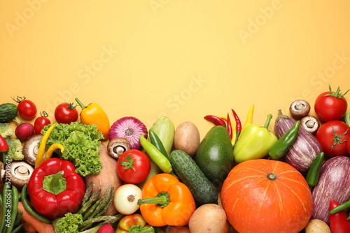 Flat lay composition with fresh vegetables on yellow background. Space for text