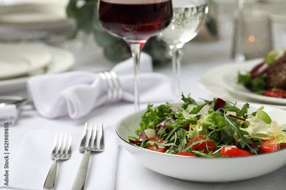 Delicious salad and wine served on table in restaurant