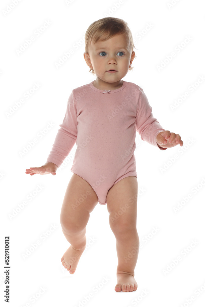 Cute baby girl in pink bodysuit learning to walk on white background Cute baby girl in pink bodysuit learning to walk on white background