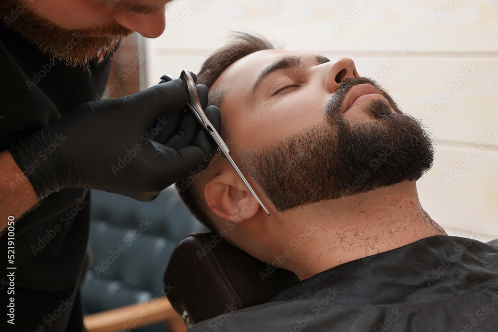 Obraz premium Professional hairdresser working with client in barbershop, closeup