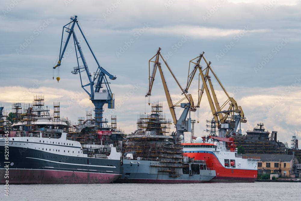construction of modern fishing minesweepers at the shipyard on the Neva River in St. Petersburg in cloudy weather