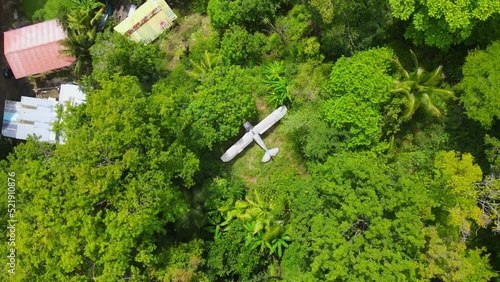 Birds eye view ascending shot, scenic view of a plane wreck in the middle of the amazon forest in Colombia. photo