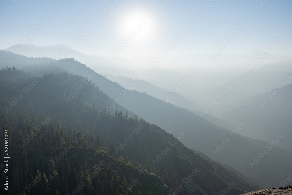 mysterious misty foggy mountains with sunlight shining through clouds