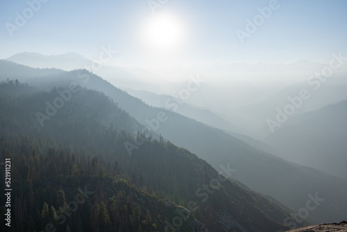 mysterious misty foggy mountains with sunlight shining through clouds © squintyi