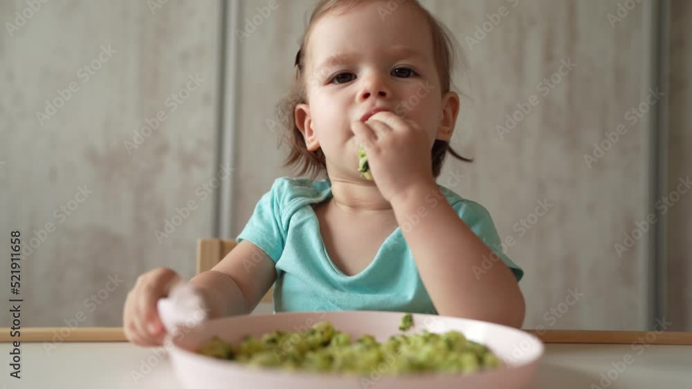 one girl small caucasian child one year old eat at the table at home one girl small caucasian child one year old eat at the table at home