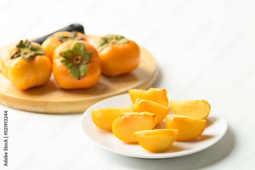Sliced ripe persimmon fruit on plate 