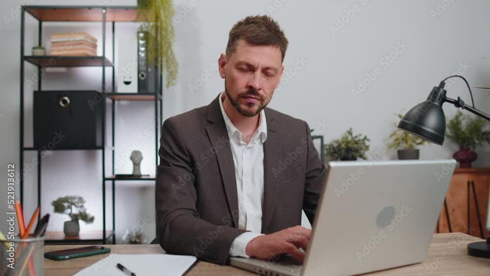 Businessman in suit working on laptop computer shakes finger and saying no, be careful, scolding and giving advice to avoid danger mistake, disapproval sign at office. Confident serious freelancer man Businessman in suit working on laptop computer shakes finger and saying no, be careful, scolding and giving advice to avoid danger mistake, disapproval sign at office. Confident serious freelancer man