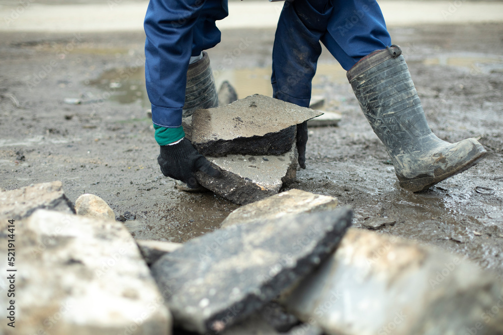 Worker lays stones. Cleaning of construction waste. Worker lays stones. Cleaning of construction waste.