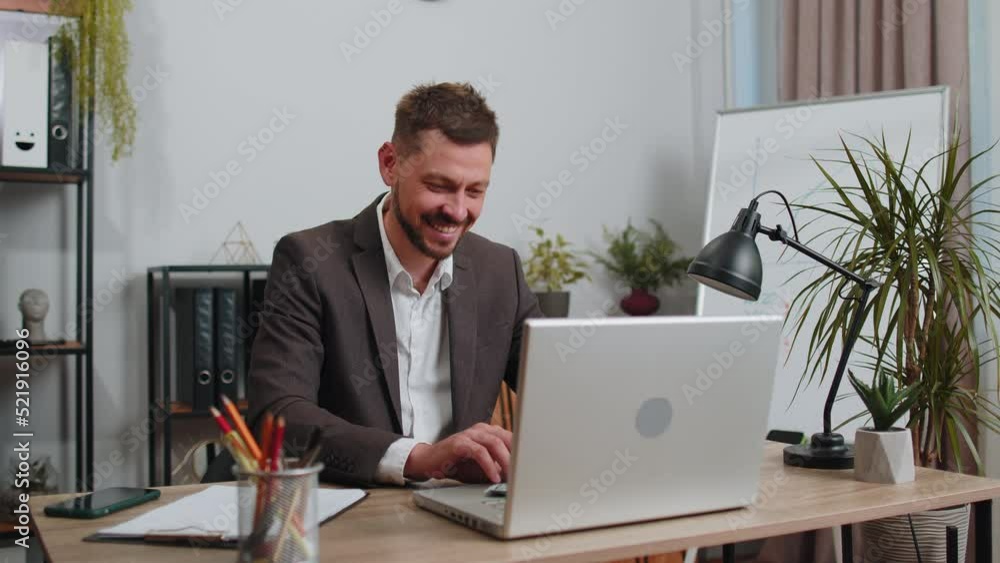 Joyful businessman in suit working on laptop computer sincerely rejoicing win, receiving money dollar cash banknotes, success lottery luck at office workplace desk. Professional manager freelancer man Joyful businessman in suit working on laptop computer sincerely rejoicing win, receiving money dollar cash banknotes, success lottery luck at office workplace desk. Professional manager freelancer man