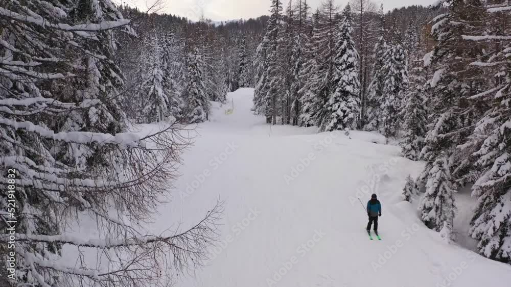 Aerial view of a cross country skier, in middle of snowy forest in Tyrol, Italy - ascending, drone shot Aerial view of a cross country skier, in middle of snowy forest in Tyrol, Italy - ascending, drone shot