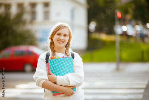 Canvas Print smiling school girl crossing crosswalk and going to school