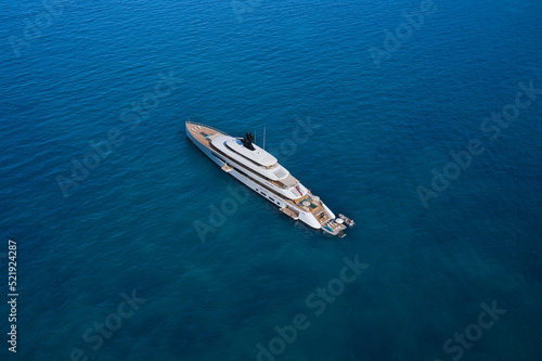 Modern big white yacht on the water top view. White big yacht at anchor aerial view. Mega yacht on water aerial view. © Berg