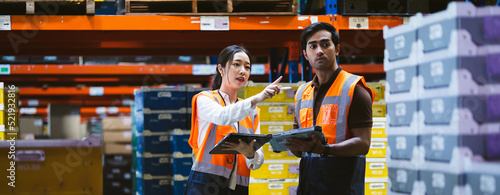 Warehouse worker and manager checks stock and inventory with digital tablet computer in the retail warehouse full of shelves with goods. Working in logistics, Distribution center.