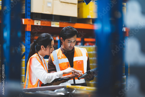 Warehouse worker and manager checks stock and inventory with using digital tablet computer in the retail warehouse full of shelves with goods. Working in logistics, Distribution center.