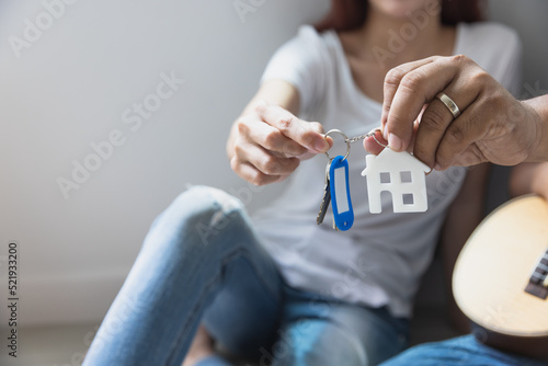 Couple holding new house key in their hands and buying a new home and are moving together.business and real estate concept
