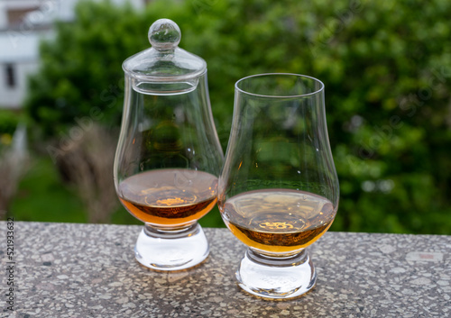 Two glasses of scotch whiskey with view on old houses on background, Edinburgh whisky tasting tour, Scotland