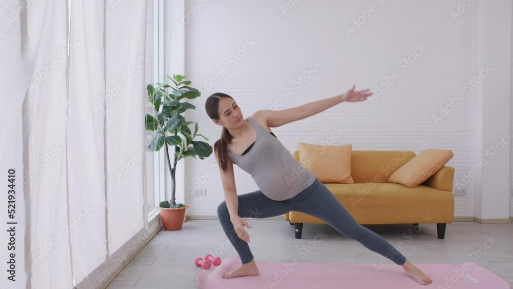 Beautiful young Asian pregnant woman in sportswear is doing yoga at home. Beautiful young Asian pregnant woman in sportswear is doing yoga at home.