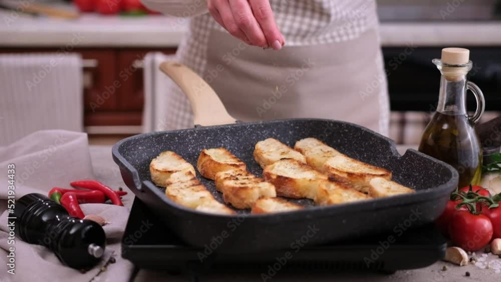 Toasting slices of baguette in a grill frying pan Toasting slices of baguette in a grill frying pan