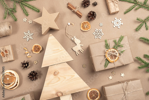 Xmas composition. Homemade wooden Christmas tree, gifts, holiday decor on craft beige background, closeup. Concept christmas zero waste, eco-friendly. Top view Flat lay