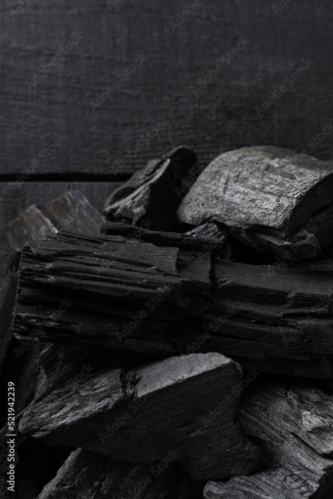 Natural wood charcoal on dark wooden background
