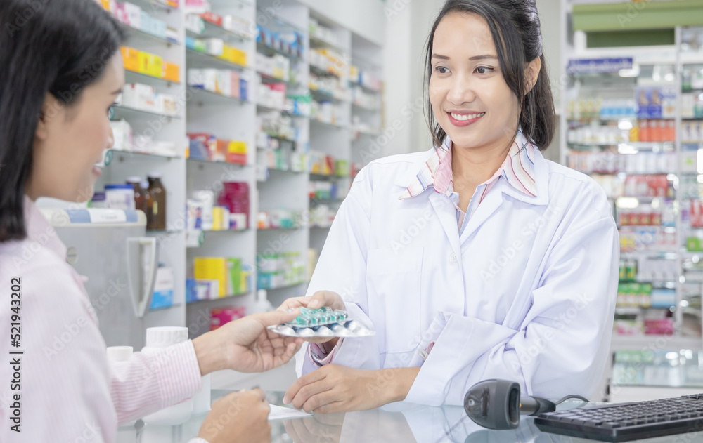 Happy female pharmacist giving prescribed medicine to customer in drug store