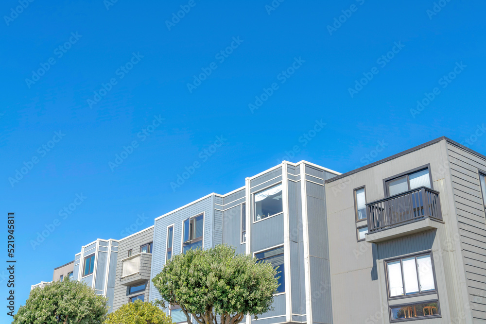 Townhomes with flat roof structures and gray wood siding in San Francisco, CA