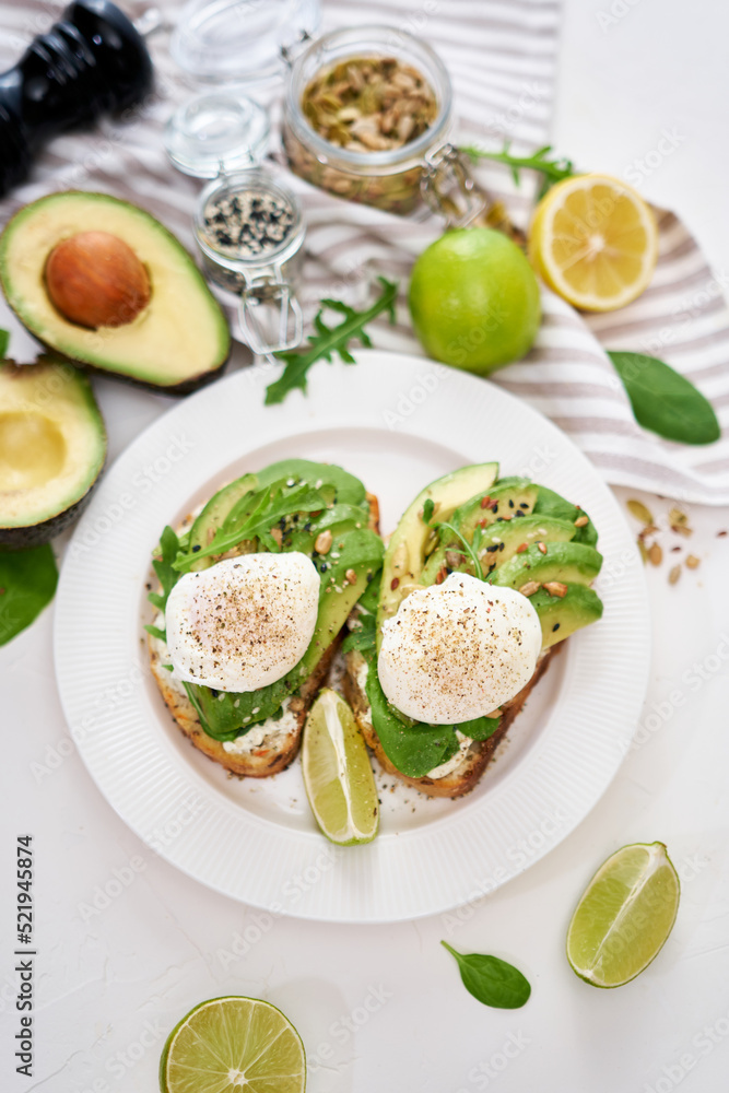 Freshly made poached egg and Avocado toasts on light grey background Freshly made poached egg and Avocado toasts on light grey background