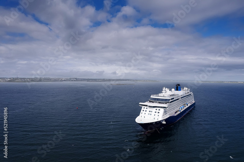 Cruise ship in the ocean. Blue cloudy sky. Tourism and travel concept. Elegant voyage by water. Aerial view. Calm water surface. Copy space. Calm and peaceful mood. © mark_gusev