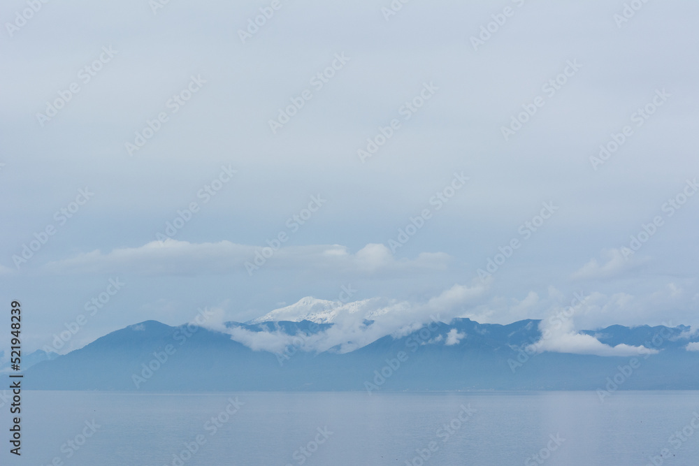 Montañas sobre el mar con nubes