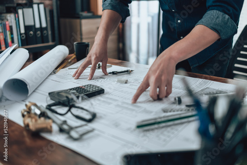 Engineering working with drawings inspection on the office desk and Calculator  triangle ruler  safety glasses  compass on Blueprint. Engineer  Architect  Industry and factory concept.