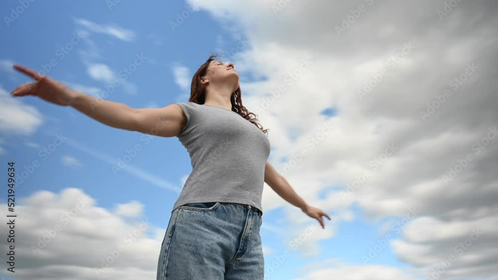 Caucasian woman spread her arms like wings against a cloudy sky. Video 360 degrees. Caucasian woman spread her arms like wings against a cloudy sky. Video 360 degrees.