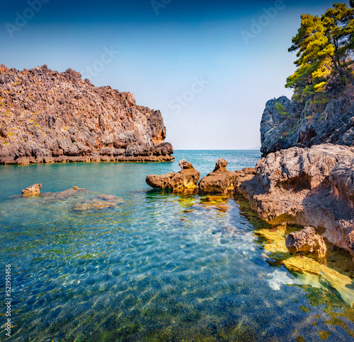 Blue water on Stelolinari beach. Sunny outdoor scene of Euboea island, Greece. Picturesque summer seascape of Myrtoan Sea. Beauty of nature concept background. photo